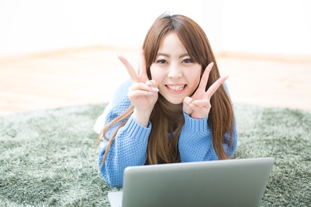The Young woman who uses the computer in a roomの写真素材