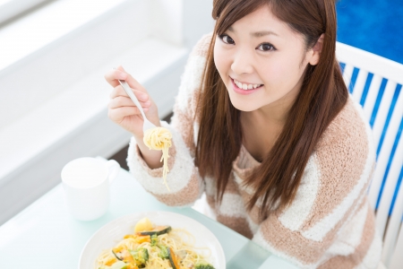young attractive asian woman who  eatsの写真素材