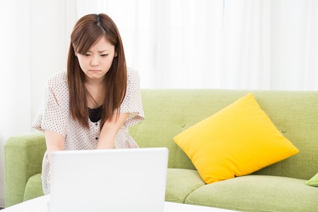 a young asian woman using laptop in the dining roomの写真素材