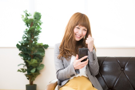Beautiful young asian businesswoman to see a smart phoneの写真素材