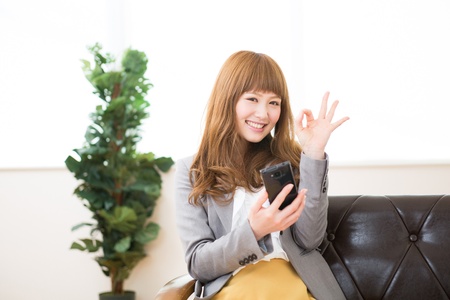 Beautiful young asian businesswoman to see a smart phoneの写真素材