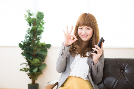 Beautiful young asian businesswoman to see a smart phoneの写真素材