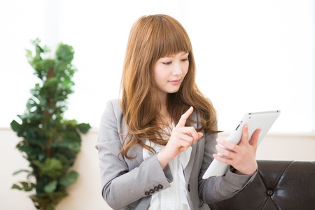 Beautiful young asian businesswoman using tablet computerの写真素材