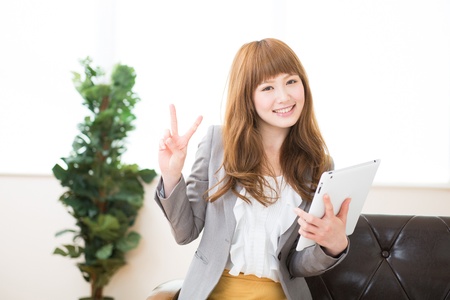 Beautiful young asian businesswoman using tablet computerの写真素材