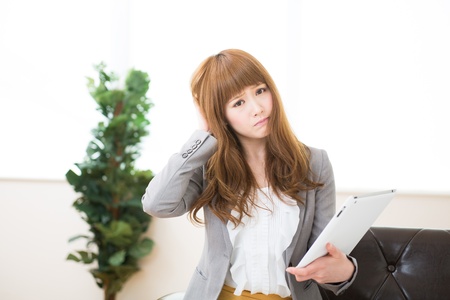 Beautiful young asian businesswoman using tablet computerの写真素材