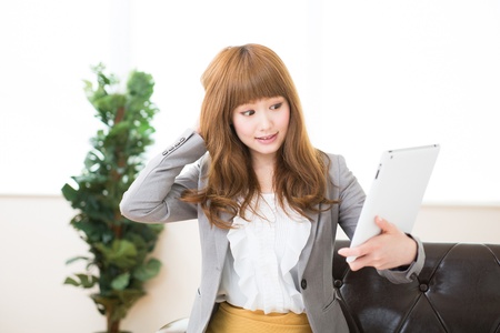 Beautiful young asian businesswoman using tablet computerの写真素材