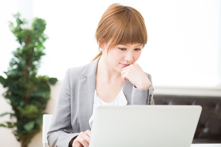 Beautiful young asian businesswoman using laptopの写真素材