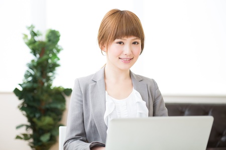 Beautiful young asian businesswoman using laptopの写真素材