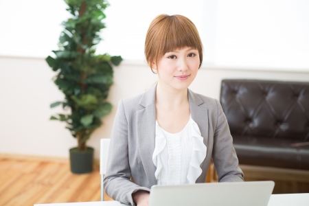 Beautiful young asian businesswoman using laptopの写真素材