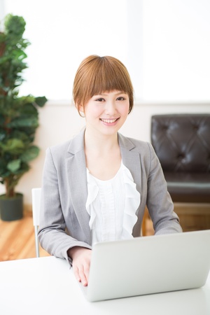Beautiful young asian businesswoman using laptopの写真素材