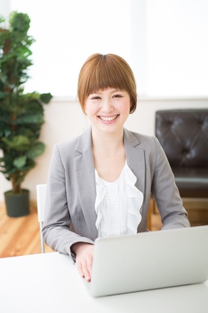 Beautiful young asian businesswoman using laptopの写真素材