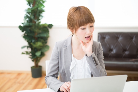 Beautiful young asian businesswoman using laptopの写真素材