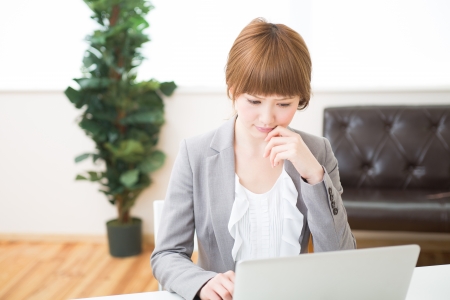Beautiful young asian businesswoman using laptopの写真素材