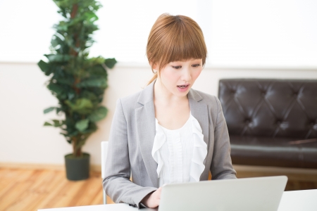 Beautiful young asian businesswoman using laptopの写真素材