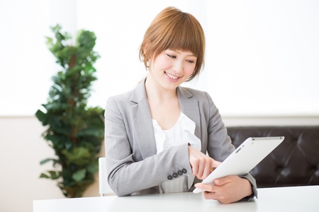 Beautiful young asian businesswoman using tablet computerの写真素材