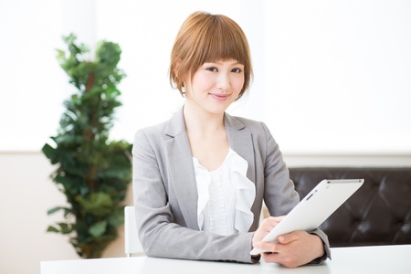 Beautiful young asian businesswoman using tablet computerの写真素材