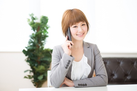 The Young businesswoman who talks on the telephoneの写真素材