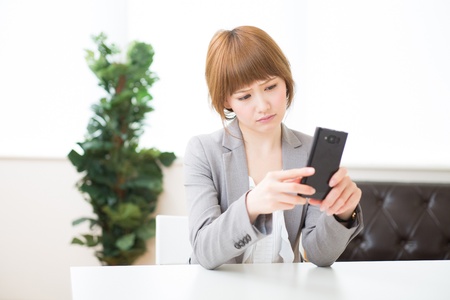 Beautiful young asian businesswoman to see a smart phoneの写真素材