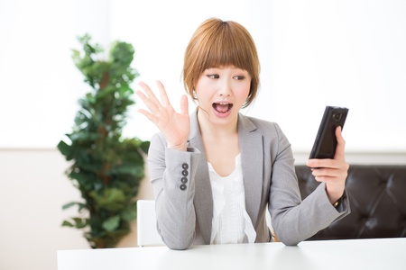 Beautiful young asian businesswoman to see a smart phoneの写真素材