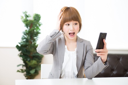 Beautiful young asian businesswoman to see a smart phoneの写真素材