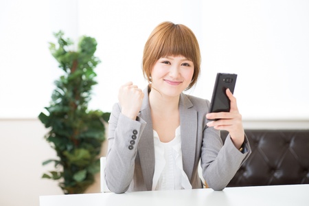 Beautiful young asian businesswoman to see a smart phoneの写真素材