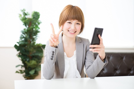 Beautiful young asian businesswoman to see a smart phoneの写真素材