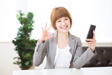 Beautiful young asian businesswoman to see a smart phoneの写真素材