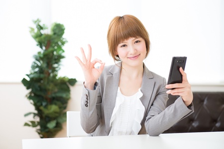 Beautiful young asian businesswoman to see a smart phoneの写真素材