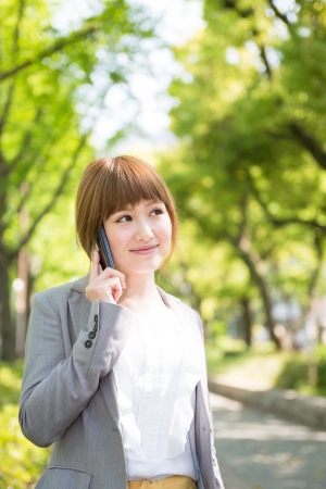 Beautiful young asian businesswoman who talks on the telephoneの写真素材