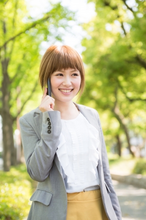 Beautiful young asian businesswoman who talks on the telephoneの写真素材