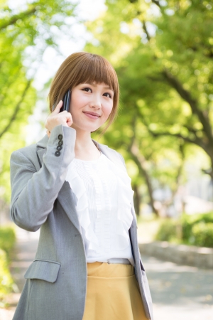 Beautiful young asian businesswoman who talks on the telephoneの写真素材