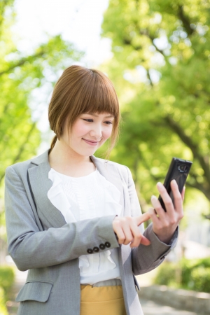 Beautiful young asian businesswoman to see a smart phoneの写真素材