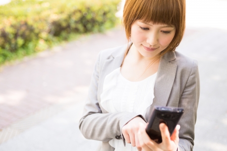 Beautiful young asian businesswoman to see a smart phoneの写真素材