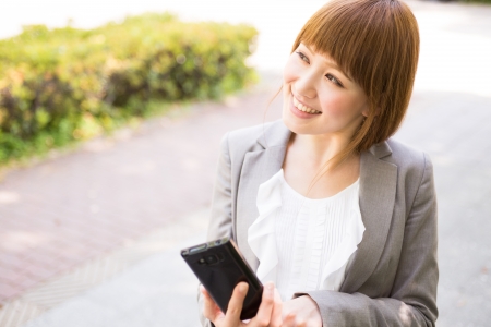 Beautiful young asian businesswoman to see a smart phoneの写真素材