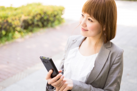 Beautiful young asian businesswoman to see a smart phoneの写真素材