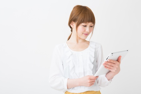 Beautiful young asian woman using tablet computerの写真素材