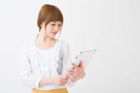 Beautiful young asian woman using tablet computerの写真素材
