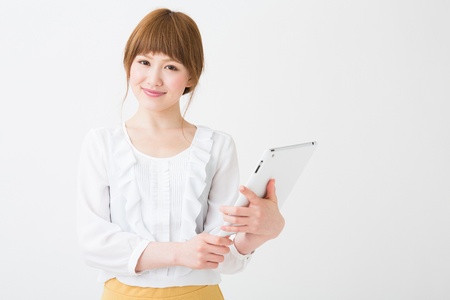 Beautiful young asian woman using tablet computerの写真素材