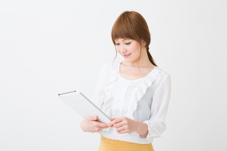 Beautiful young asian woman using tablet computerの写真素材