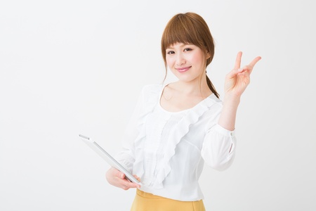 Beautiful young asian woman using tablet computerの写真素材