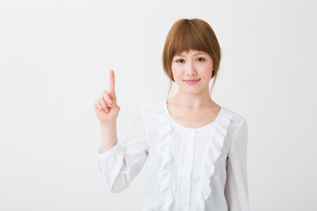 young attractive asian woman indicating the number oneの写真素材