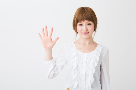 young attractive asian woman indicating the number fiveの写真素材
