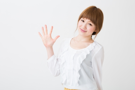 young attractive asian woman indicating the number fiveの写真素材