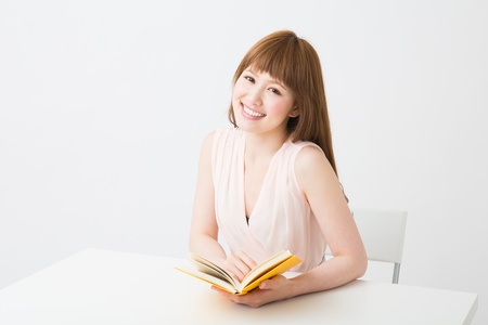 young attractive asian woman who reads a bookの写真素材