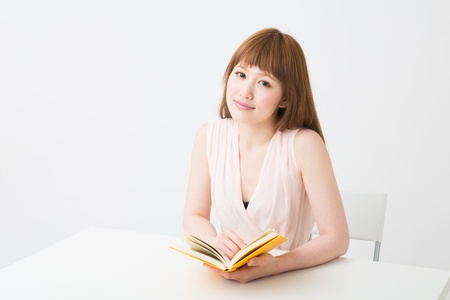 young attractive asian woman who reads a bookの写真素材