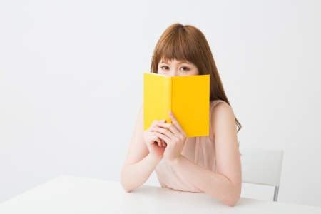 young attractive asian woman who reads a bookの写真素材