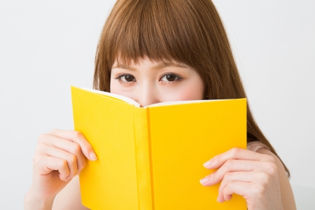 young attractive asian woman who reads a bookの写真素材
