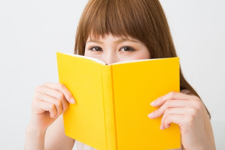 young attractive asian woman who reads a bookの写真素材
