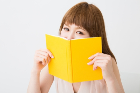 young attractive asian woman who reads a bookの写真素材