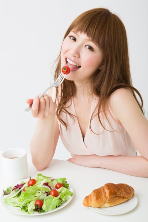 young attractive asian woman who  eatsの写真素材